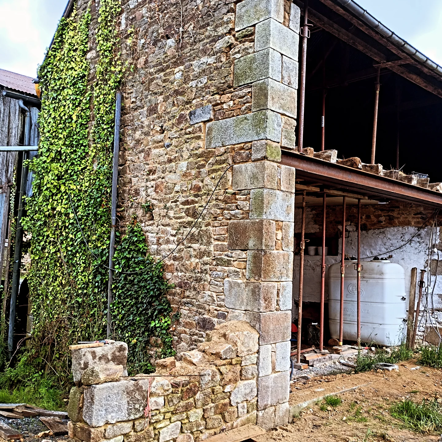 Chaînage d'angle en granit et mur en moellons repris à la chaux