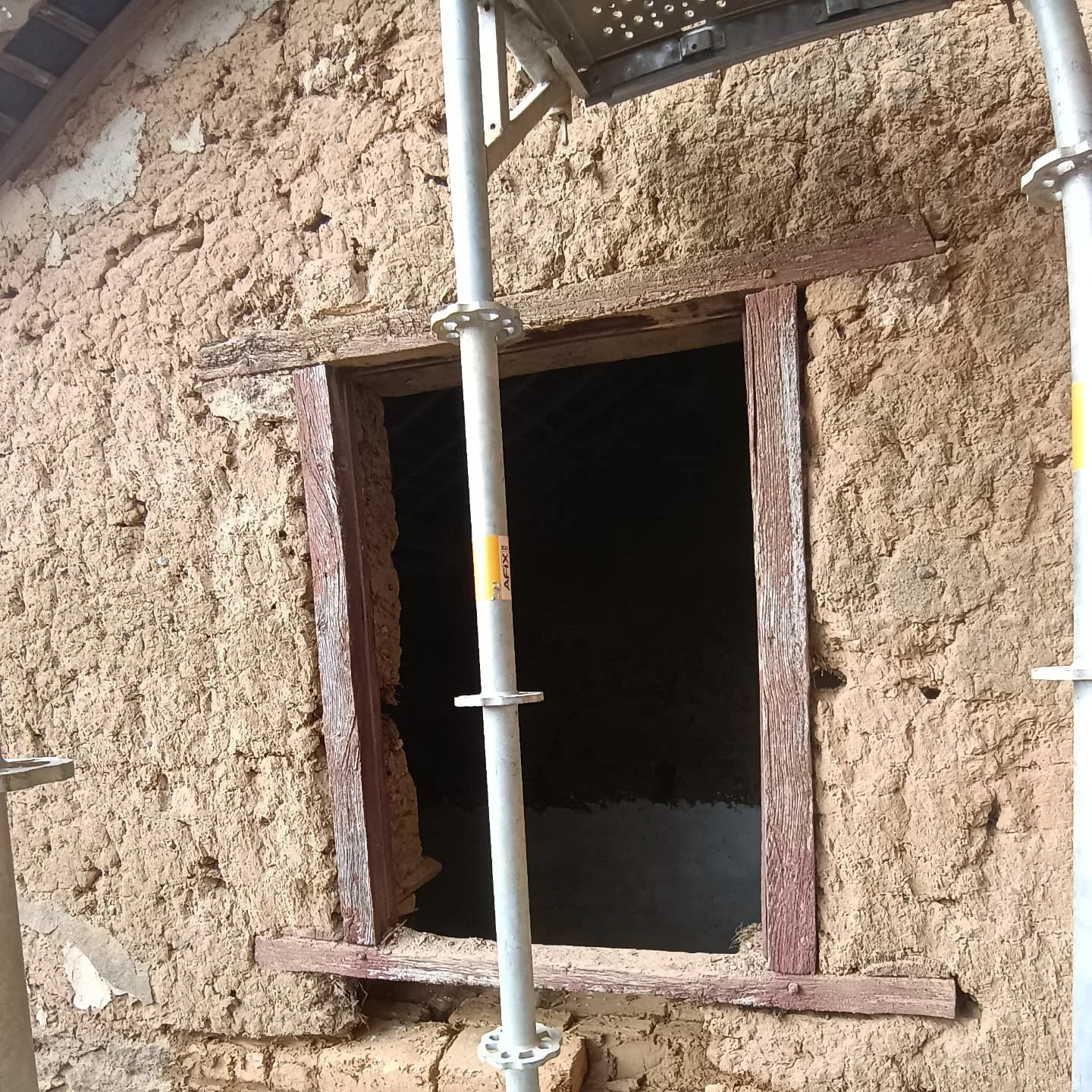 Fenêtre à linteau bois dans un mur en terre crue