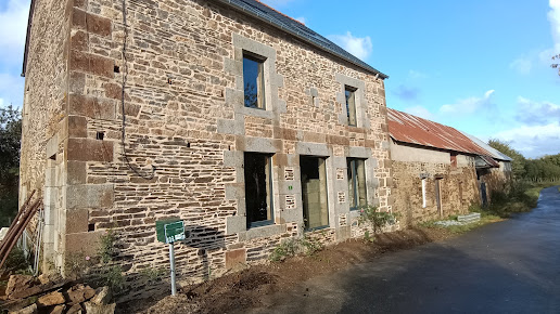 Façade de longère en pierre rejointoyée en bord de route
