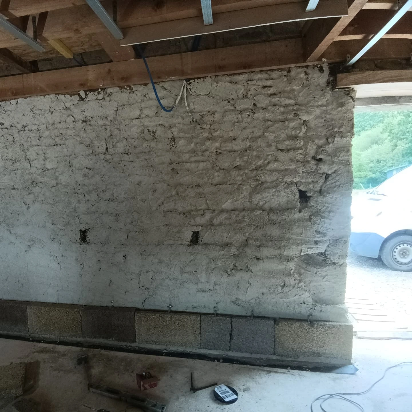 Mur intérieur en pierre décroûté et repris en sous-œuvre